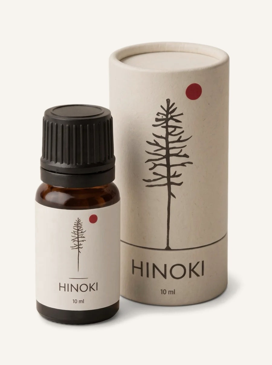 A bottle of Hinoki Oil beside its paper tube